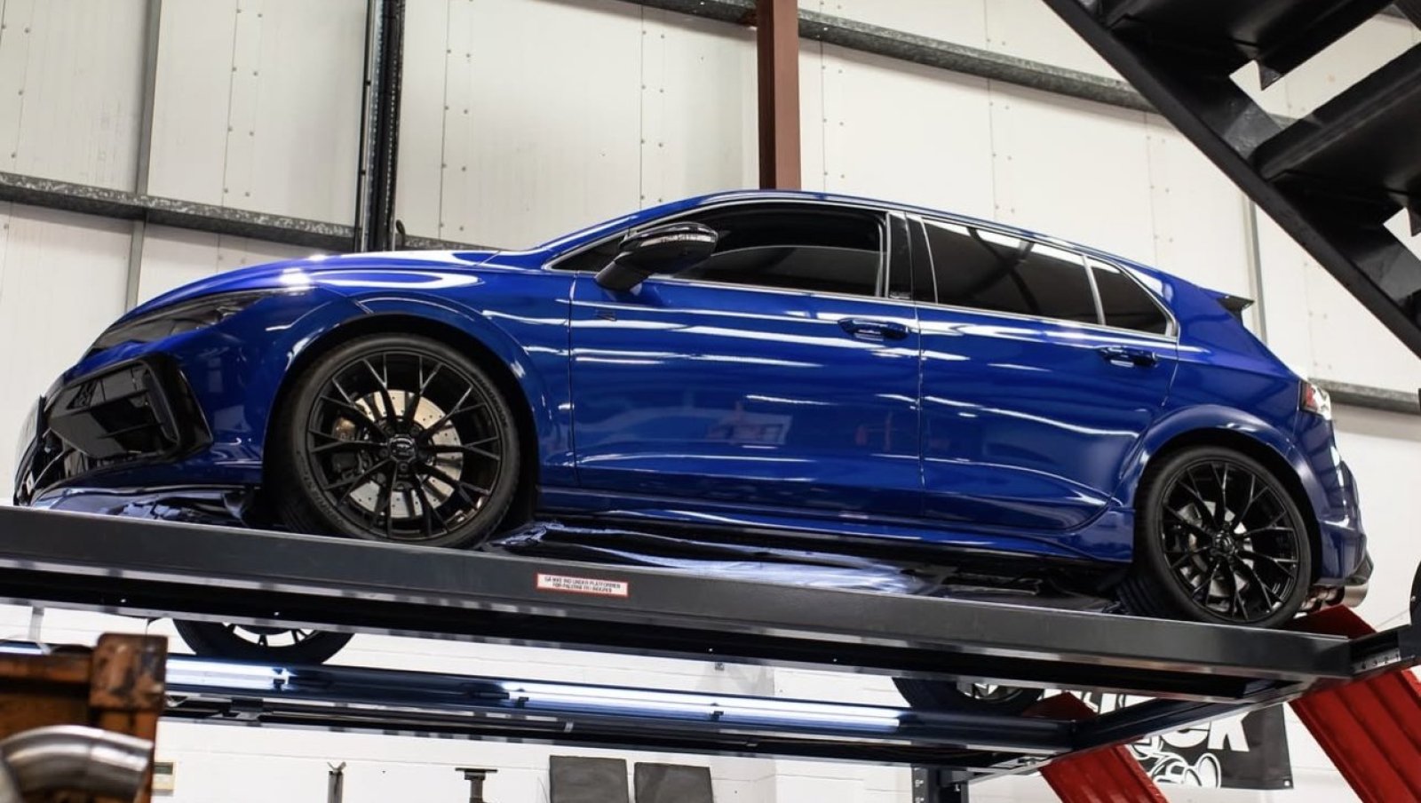 Blauer VW Golf 8 R mit Tuning-Umbau auf der Hebebühne in der Werkstatt