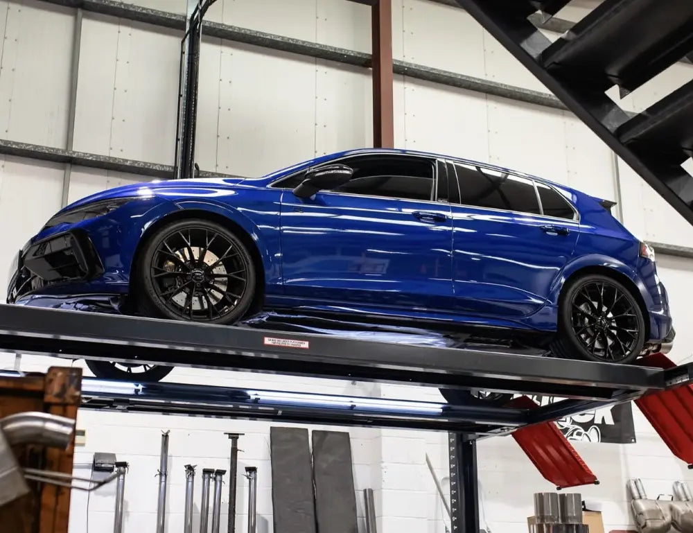 Blauer VW Golf 8 R mit Tuning-Umbau auf der Hebebühne in der Werkstatt
